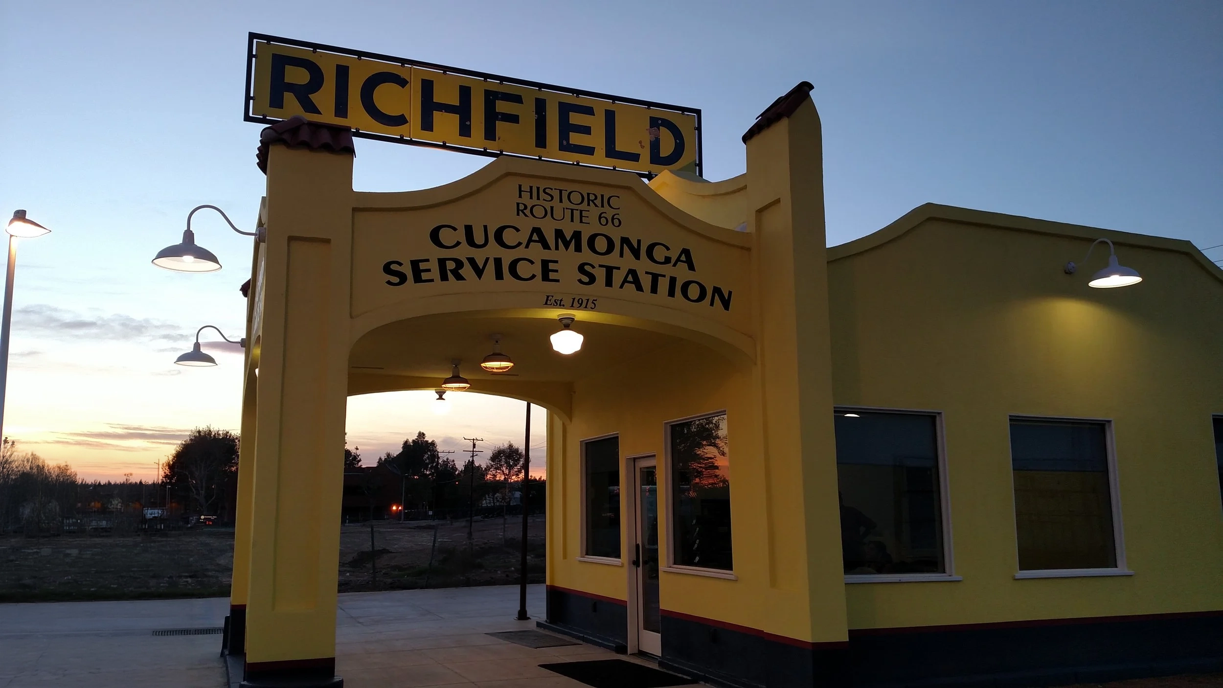 The Historic Cucamonga Service Station at dusk, with its lit Richfield sign