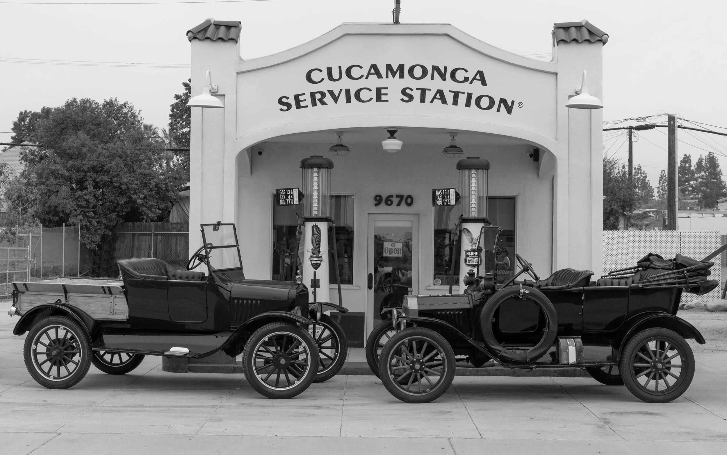 Two restored Model T cars parked in front of the Cucamonga Service Station